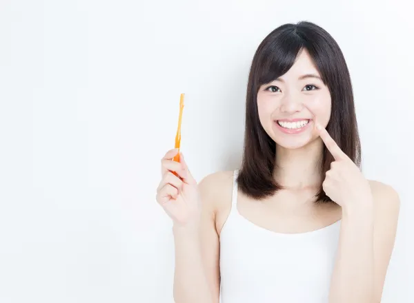 歯ブラシを手に微笑む女性