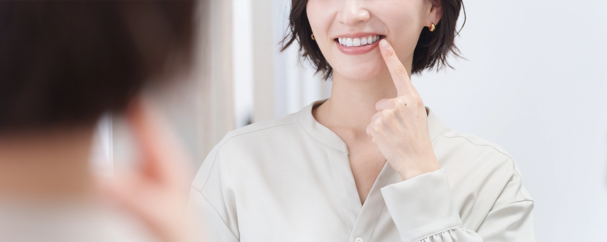 頬に指を添えて微笑む女性